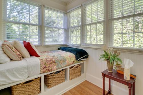 a bedroom with windows and a bed and a table at 7 Mi to The Biltmore Le Canard Cottage with Porch in Arden