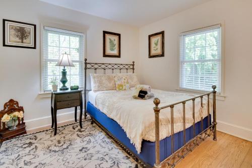 um quarto com uma cama, uma mesa de cabeceira e 2 janelas em Le Canard Cottage with Porch 10 Mi to Asheville! em Arden