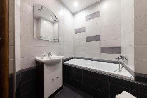 ein Badezimmer mit einem Waschbecken und einer Badewanne in der Unterkunft Apartament z widokiem in Białystok