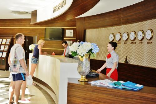 a group of people standing around a counter with flowers at Eldar Resort Hotel in Kemer