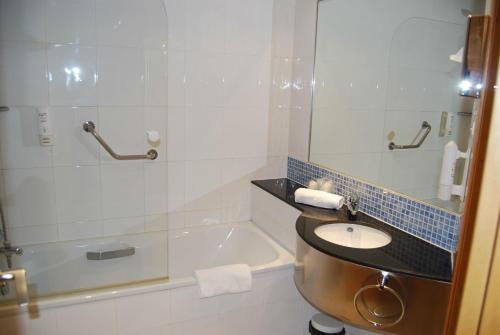 a bathroom with a sink and a bath tub at Holiday Inn Express Valencia Bonaire by IHG in Aldaya