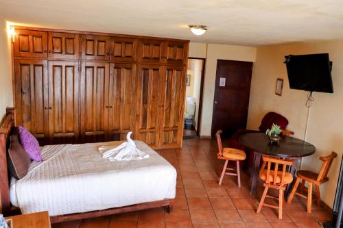 a bedroom with a bed and a table and a television at Hotel Chocolate Suites in Guanajuato