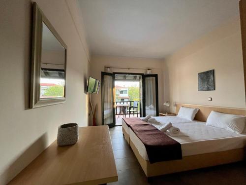 a bedroom with a bed and a table and a window at Eden Hotel in Afitos