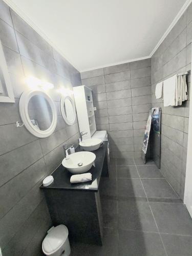 a bathroom with a sink and a toilet and a mirror at Villa Gardiki for2 in Halikounas