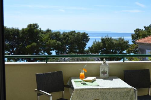einen Tisch und Stühle auf einem Balkon mit Meerblick in der Unterkunft Rooms & Apartments Villa Anka in Tučepi