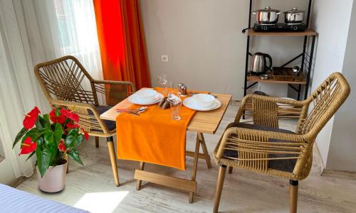einen Esstisch mit 2 Stühlen und einem orangenen Tischtuch in der Unterkunft AURA HOTEL in Istanbul