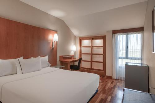 una habitación de hotel con una gran cama blanca y una ventana en AC Hotel Palencia by Marriott, en Palencia