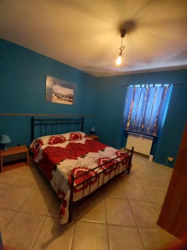 een slaapkamer met een bed en een blauwe muur bij Appartamento nel cuore del centro storico in Valmontone