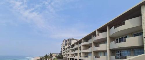 an apartment building with the ocean in the background at Blue Largo Sea View in Westbrook