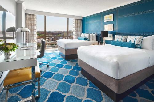a hotel room with two beds and a blue wall at The Ven at Embassy Row, Washington, D.C., a Tribute Portfolio Hotel in Washington