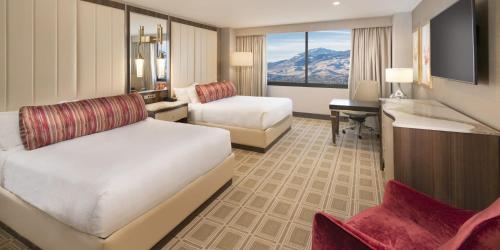 a hotel room with two beds and a desk at Grand Sierra Resort and Casino in Reno