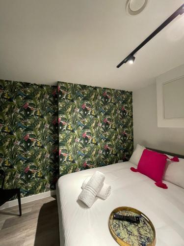 a small bedroom with a bed with a floral wallpaper at The Phoenix Collection in Liverpool