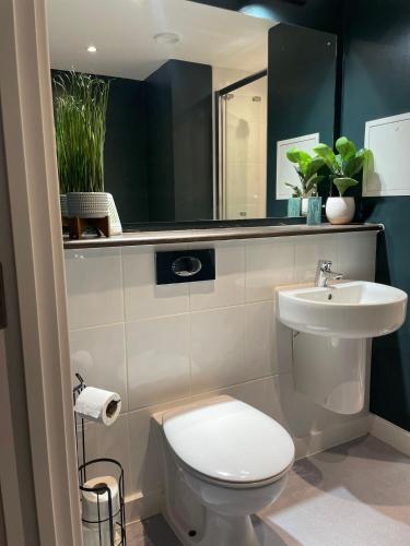 a bathroom with a white toilet and a sink at The Phoenix Collection in Liverpool