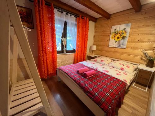 a small bedroom with a bed and a window at Domki w Tajemniczej Krainie in Wetlina