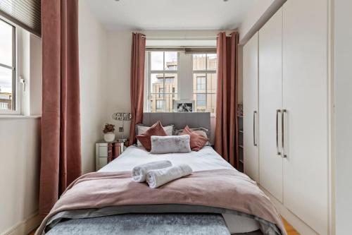 Westminster Big Ben Apartment في لندن: غرفة نوم عليها سرير وفوط
