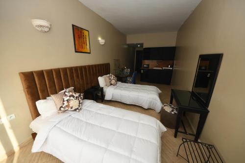 Agyad Maroc Appart-Hotel في أغادير: غرفة فندقية بسريرين وطاولة