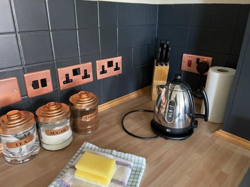 a kitchen counter with a tea kettle and spices at Rambler’s Retreat in Dersingham