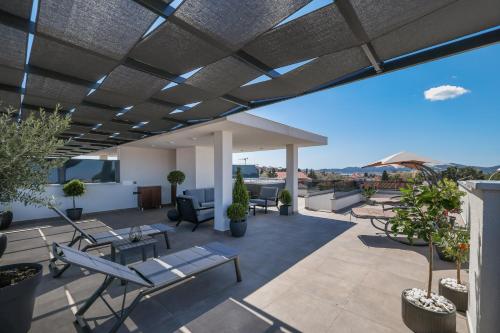 a patio with chairs and tables on a roof at Leonardo Luxury Residence 2 Penthouse with jacuzzi in Zadar