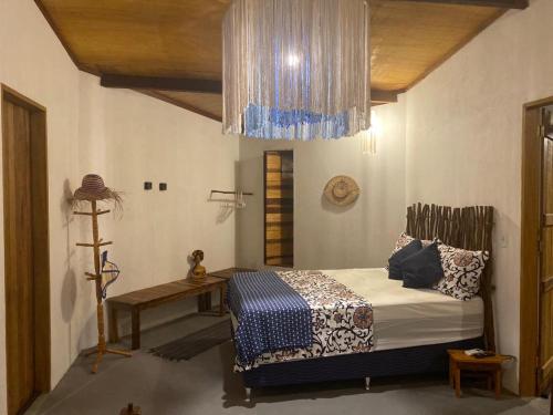 a bedroom with a bed and a chandelier at Casa do Francês in Japaratinga