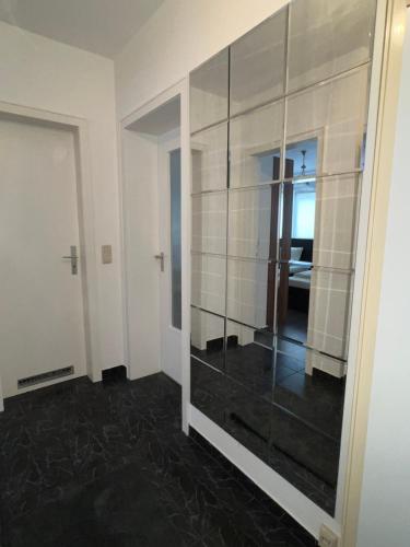 Zimmer mit einem großen Spiegel und einem Schlafzimmer in der Unterkunft Nik Apartment in Oberhausen