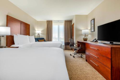 a hotel room with two beds and a flat screen tv at Comfort Inn & Suites in Napanee