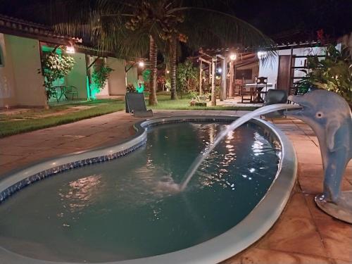 Una piscina con un elefante rociando agua desde una fuente. en Pousada Gostoso Village, en São Miguel do Gostoso