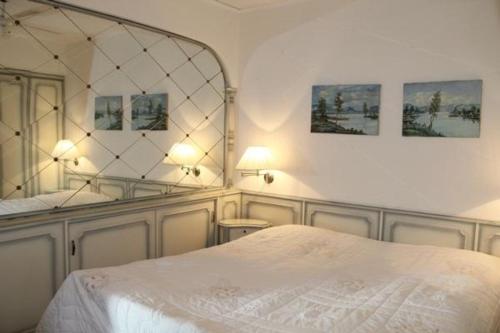 RuviglianaにあるBarony "Olive" Komfort-Wohnung Castagnola-Seenähe mit Garten für Hund, Klimagerät, Hallenbadのベッドルーム(大きな鏡付きの白いベッド付)