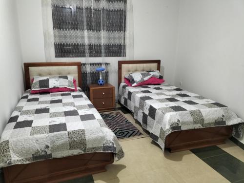 dos camas sentadas una al lado de la otra en una habitación en MAÏS en Argel