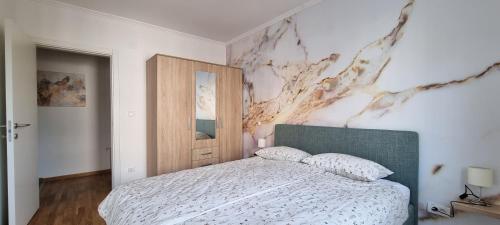 a bedroom with a bed and a painting on the wall at Apartman Visnja in Subotica