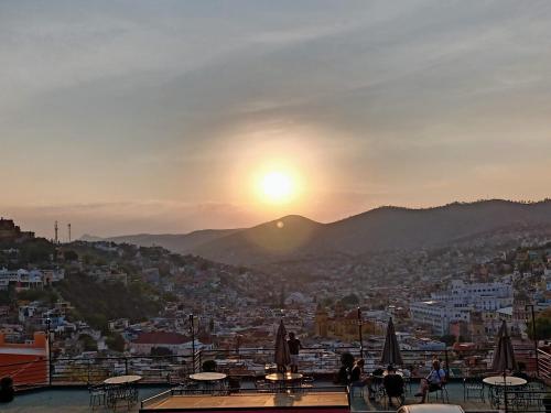a view of the sun setting over a city at Hotel Chocolate Suites in Guanajuato