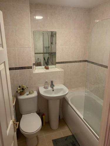 a bathroom with a toilet and a sink and a tub at Sovereign Harbour Eastbourne Rooms in a Holiday Home in Eastbourne