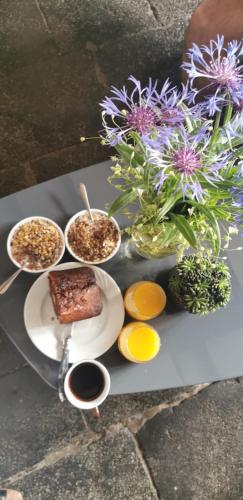 a table with plates of food and flowers on it at Chez Kahina ancien hôtel Robert in Giat