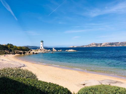 uma praia com um farol na água em Blumarine em Palau