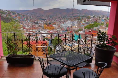 a balcony with a table and chairs and a view of a city at Hotel Chocolate Suites in Guanajuato