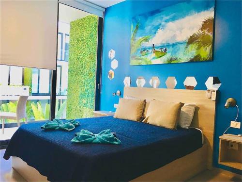 a blue bedroom with a bed with a blue wall at Estudio exclusivo in The City - TOP amenidades! in Playa del Carmen