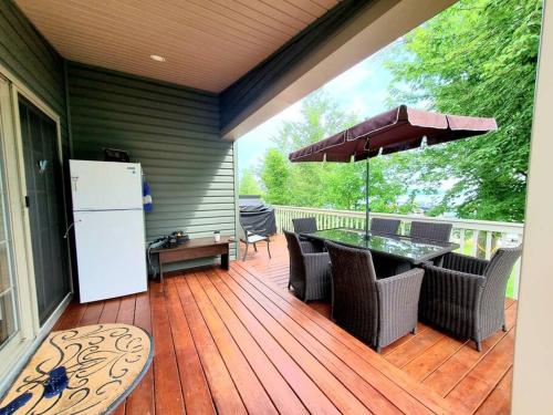 a wooden deck with a table and a refrigerator at Water Front very spacious Cottage on Rice Lake with 5 Star Golf Resort in Keene
