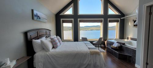 um quarto com uma cama grande e uma janela grande em Coastal Lookout Suites em Corner Brook