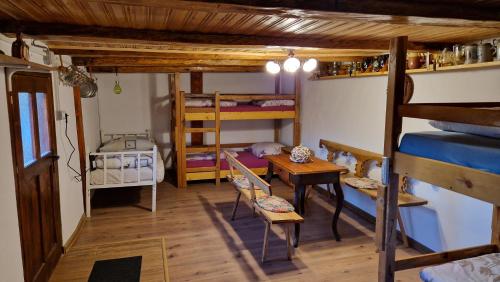 a room with two bunk beds and a table at La sălaşul fermecat în Cheile Carasului in Iabalcea