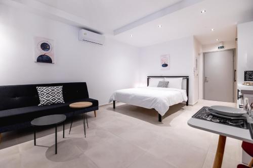 ein Schlafzimmer mit einem Bett, einem Sofa und einem Tisch in der Unterkunft Pagani Blue - Luxury Studio A2 in Faraí
