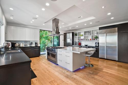 una grande cucina con elettrodomestici in acciaio inossidabile e pavimenti in legno di Villa Alana a Los Angeles