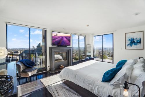 um quarto com uma cama grande e janelas grandes em Villa Alana em Los Angeles