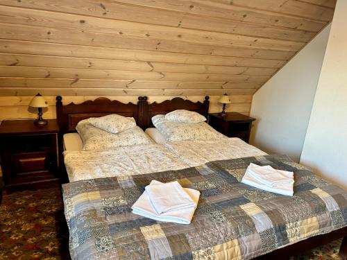 a bedroom with a bed with two books on it at Leśne PoBudki in Białowieża