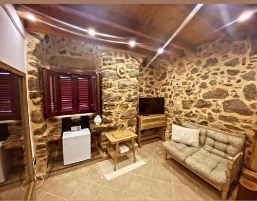 a room with a stone wall with a couch and a table at August castle house in Mestá