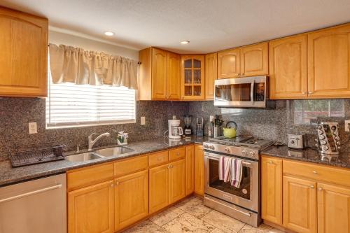 a kitchen with wooden cabinets and a sink and a stove at Vallejo Home with Spacious Deck, Hot Tub and Views in Vallejo