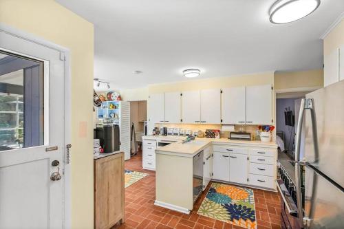 a kitchen with white cabinets and a refrigerator at Magnolia on the Hill in Seattle