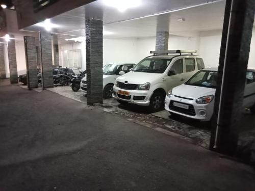 two white cars parked in a parking garage at Pinehill Suits in Ooty