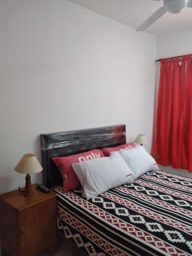 ein Schlafzimmer mit einem Bett mit einem roten Vorhang in der Unterkunft Los Girasoles del Sur in Wilde
