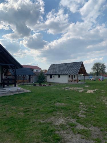 una granja con dos edificios y un campo de césped en Domek letniskowy 6-osobowy całoroczny nad jeziorem Wilczyńskim, en Świętne