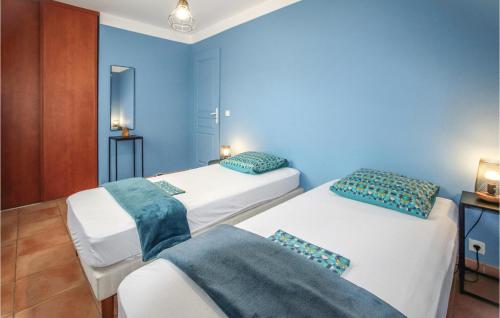 - 2 lits dans une chambre aux murs bleus dans l'établissement 3 Bedroom Beautiful Home In Saint-thom, à Saint-Thomé