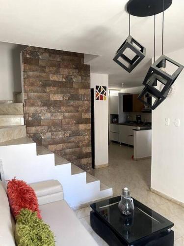 a living room with a couch and a brick wall at Casa Carolina in Santa Marta